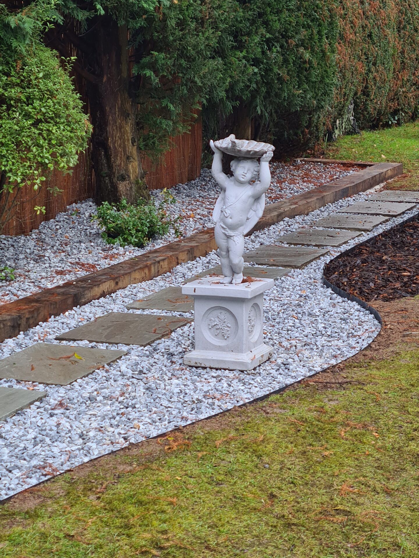 stone and slab pathway with garden ornament.
