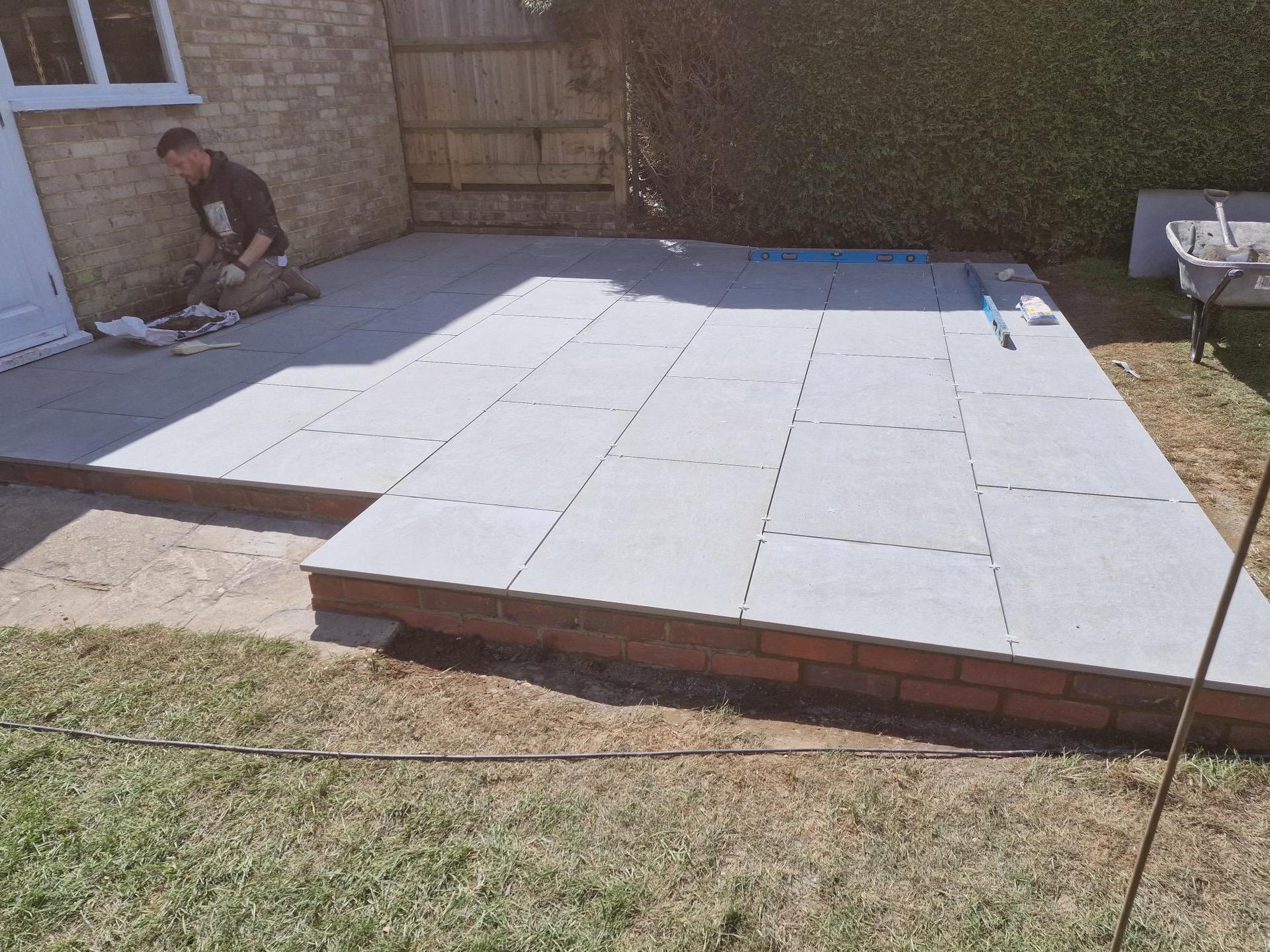 Patio with grey slabs nearing completion.
