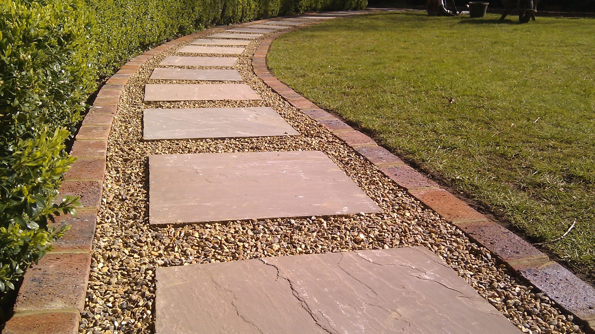 winding path - paving slabs in shingle - leading away next to lawn.